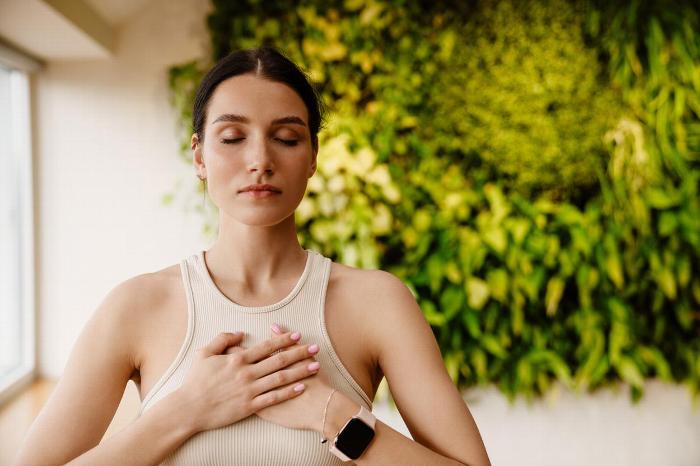 Woman meditating with hands on heart
